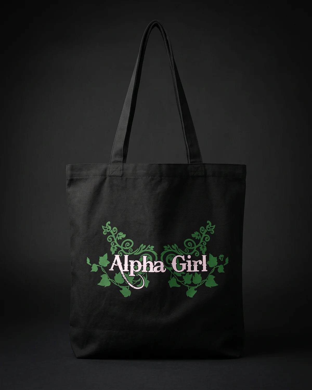 Black tote printed with the Alpha Girl wordmark inside green ivy